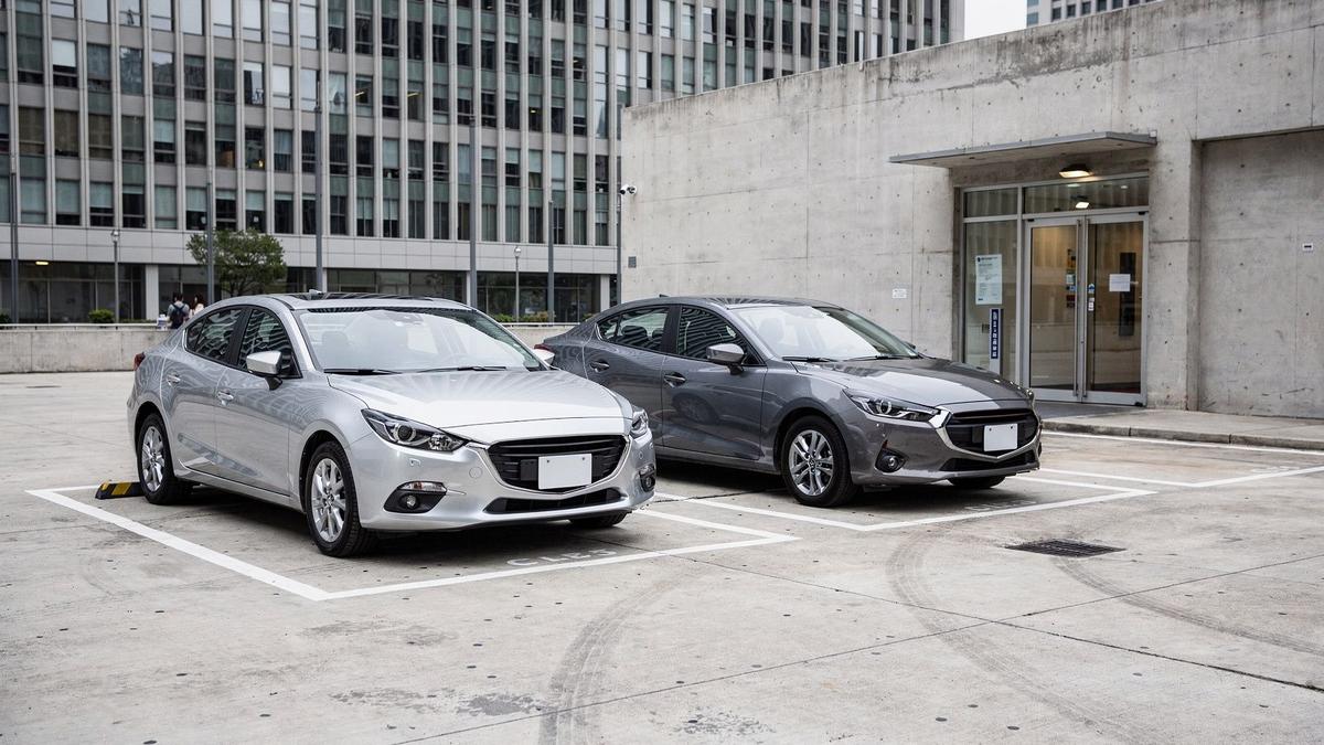 Row of rental cars parked in a marked handover bay at a city pickup desk